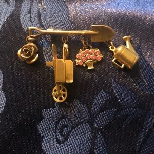 Pin with garden-themed charms:shovel, rose, wheelbarrow, flowerpot, watering can